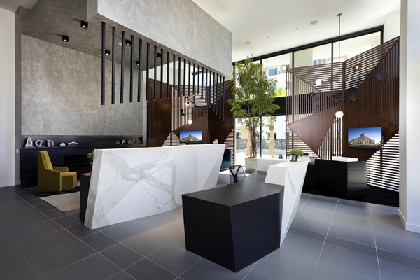 Modern office lobby with geometric decor and marble reception desk at Jefferson Edge Apartments
