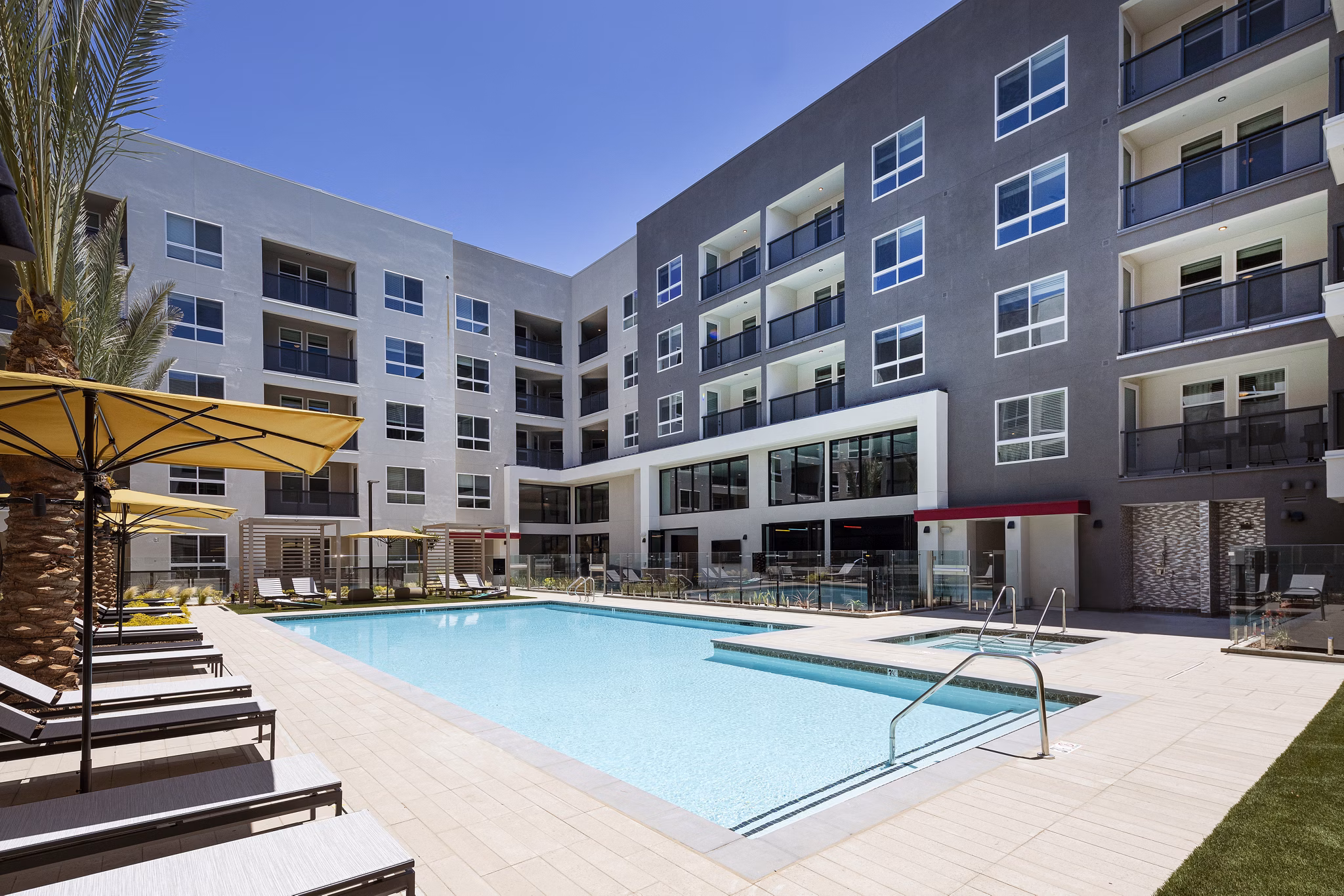 Resort-style pool at Jefferson Edge Apartments with lush landscaping and ample lounge seating