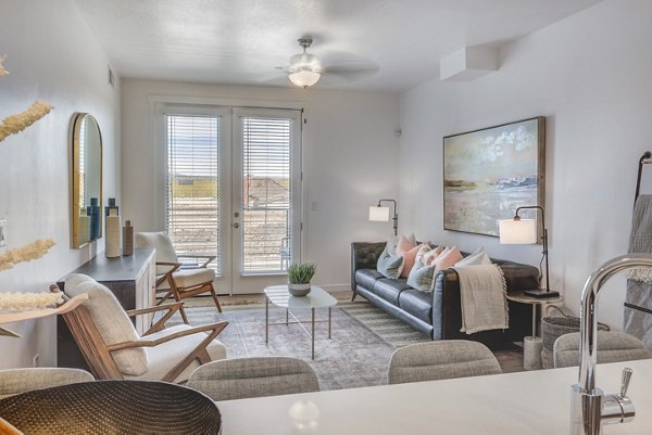 Modern living room with plush seating and large windows at Vida at Daybreak Apartments