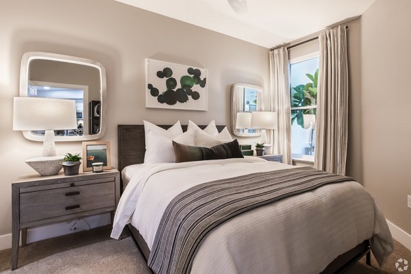 Gio Apartments: Cozy bedroom with modern furnishings and ample natural light, luxury living in a vibrant community