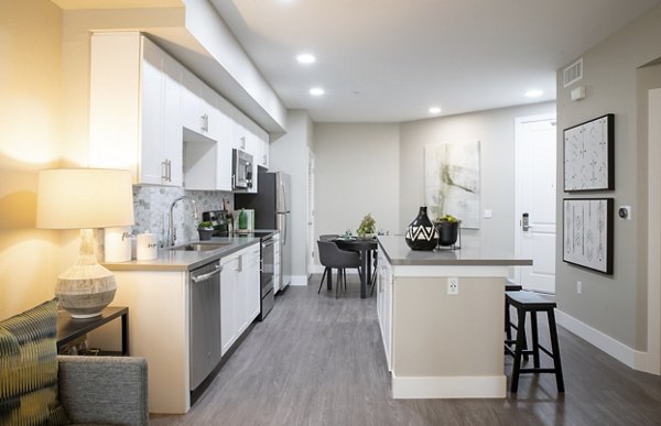 Modern kitchen with sleek appliances and island counter at Gio Apartments