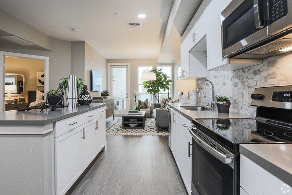 Modern kitchen with sleek appliances and quartz countertops in Gio Apartments