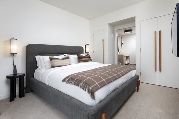 Bedroom featuring modern design and plush bedding at Columbia Square Living Apartments