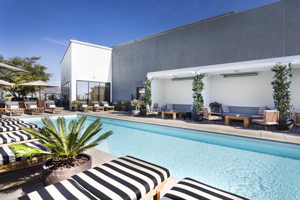 Resort-style pool surrounded by lush landscaping at Columbia Square Living Apartments