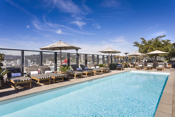 Pool with lounge chairs at Columbia Square Living Apartments, luxury community featuring resort-style amenities and modern design Perfect for relaxation and leisure