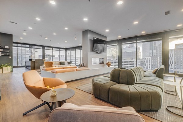 Modern clubhouse featuring cozy seating and large TV at The Morton Apartments
