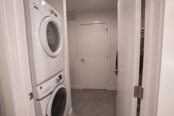 Laundry room featuring modern washers and dryers at The Morton Apartments, a luxury living community by Greystar