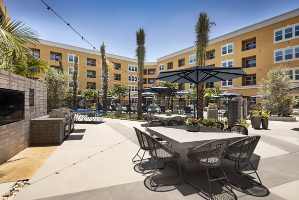 Outdoor grill area with modern seating at Lex CTR City Apartments