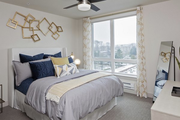Cozy bedroom with plush bedding and natural light in Marvelle at Southcenter Apartments, luxury living spaces near Seattle