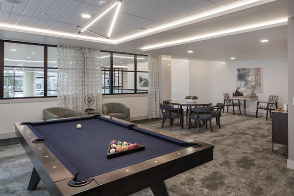 Modern game room featuring billiards and gaming consoles at Marvelle at Southcenter Apartments