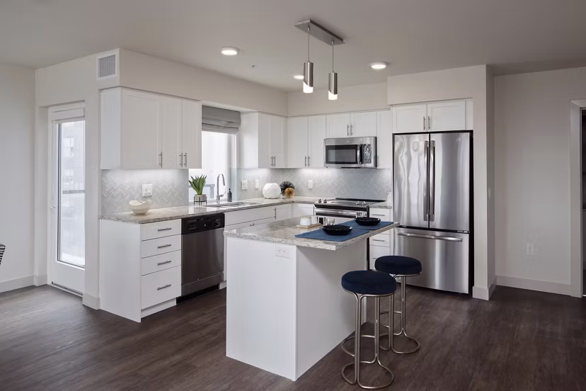 Modern kitchen with stainless steel appliances and quartz countertops in Marvelle at Southcenter Apartments