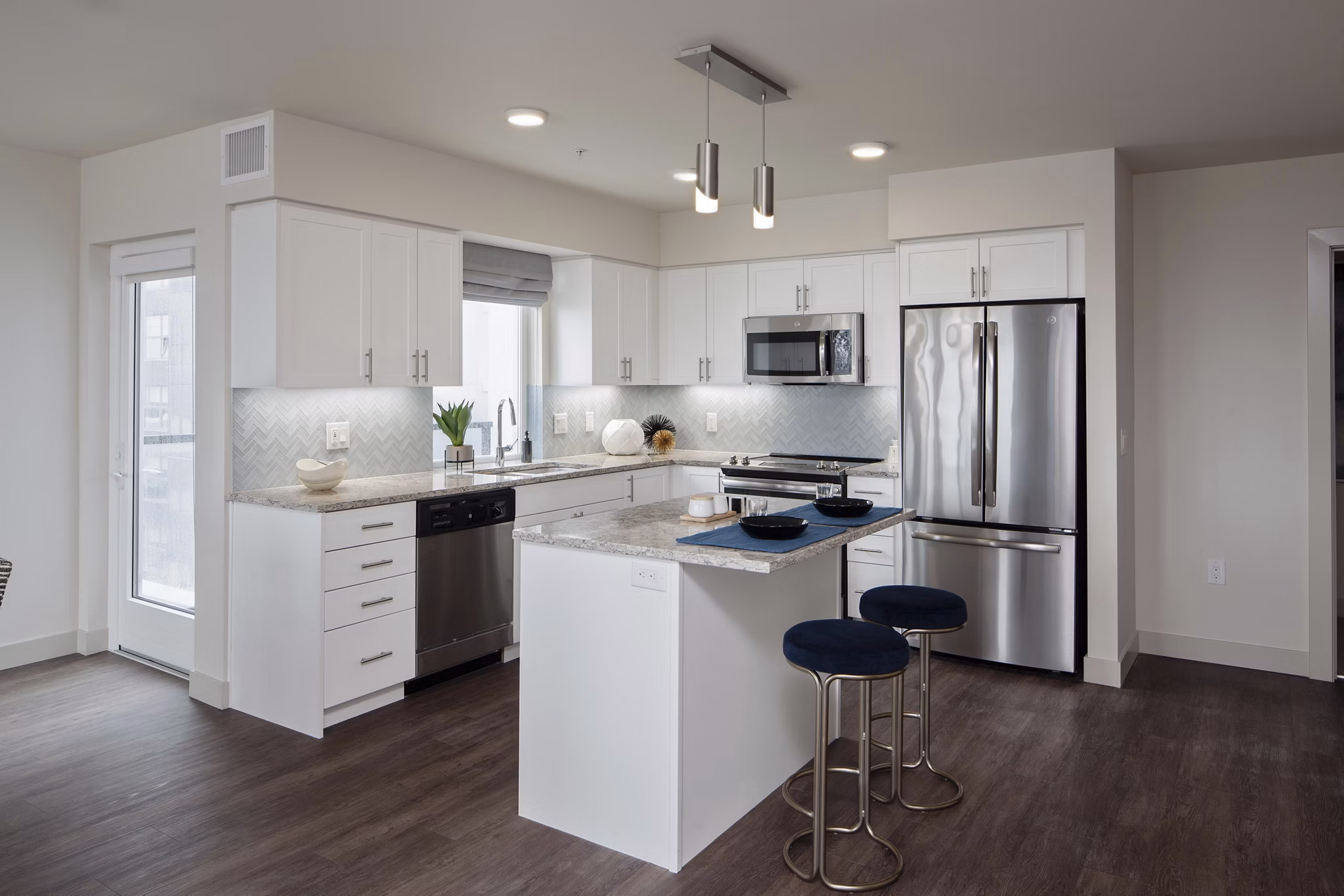 Modern kitchen with stainless steel appliances and quartz countertops in Marvelle at Southcenter Apartments