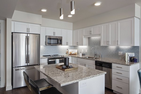 Modern kitchen with sleek countertops and stainless steel appliances at Marvelle at Southcenter Apartments
