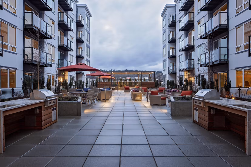 Outdoor grill area at Marvelle at Southcenter Apartments featuring modern BBQ stations and seating, perfect for entertaining and social gatherings