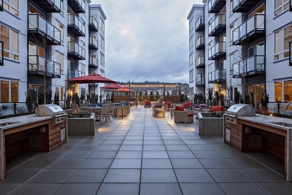 Outdoor grill area at Marvelle at Southcenter Apartments featuring modern BBQ stations and seating, perfect for entertaining and social gatherings