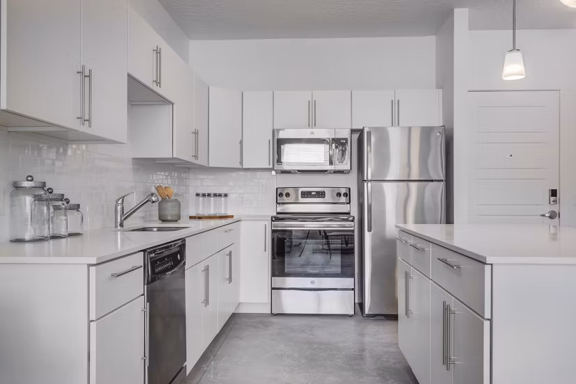 Modern kitchen featuring stainless steel appliances and granite countertops at Brixton Apartments