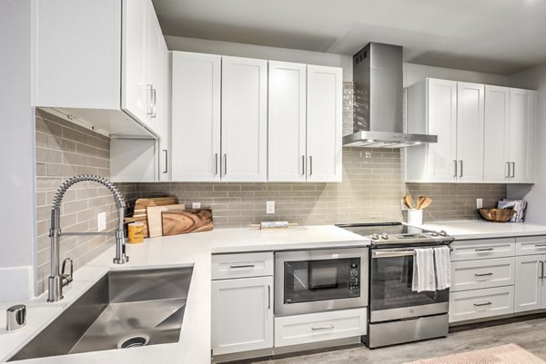 Modern kitchen featuring stainless steel appliances and granite countertops at Ironwood North Apartments