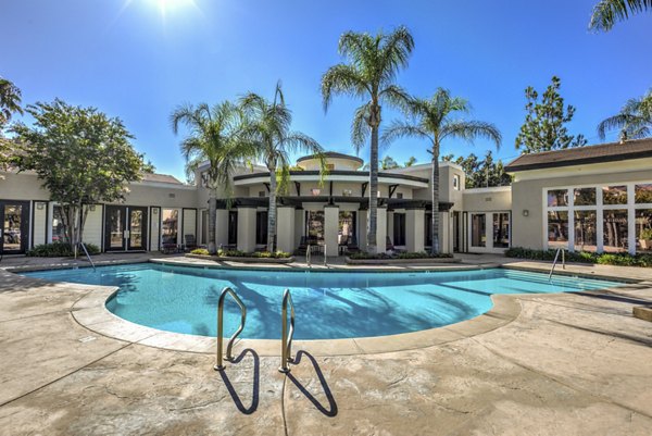 Resort-style pool area at Ironwood North Apartments with lounge chairs and lush landscaping
