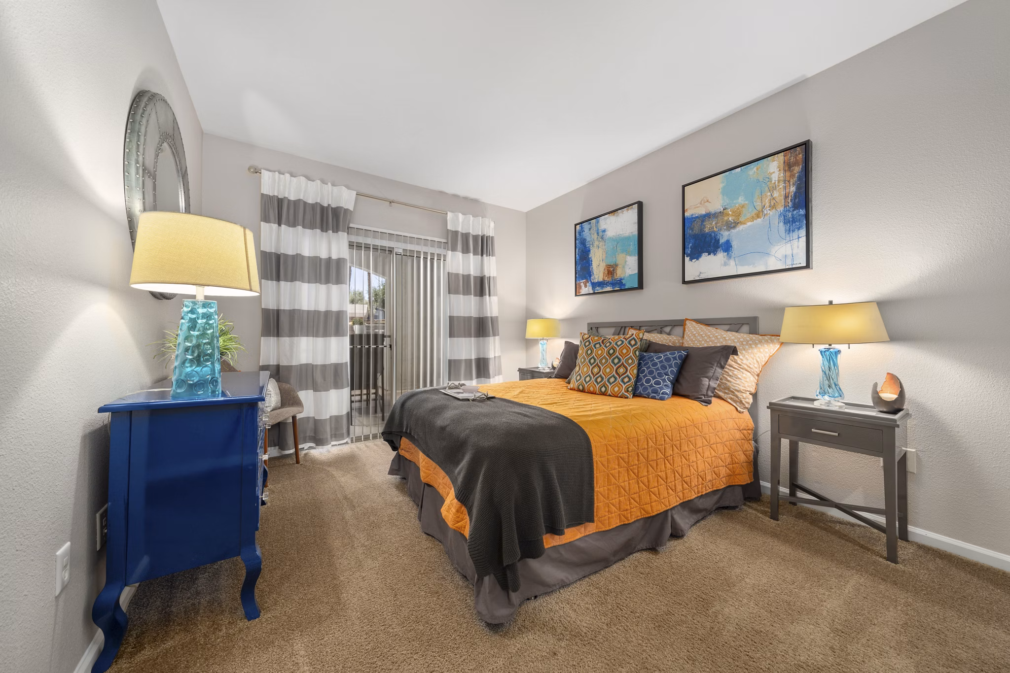 Cozy bedroom with modern decor at Artessa Apartments, featuring large windows and stylish furnishings in a luxury setting