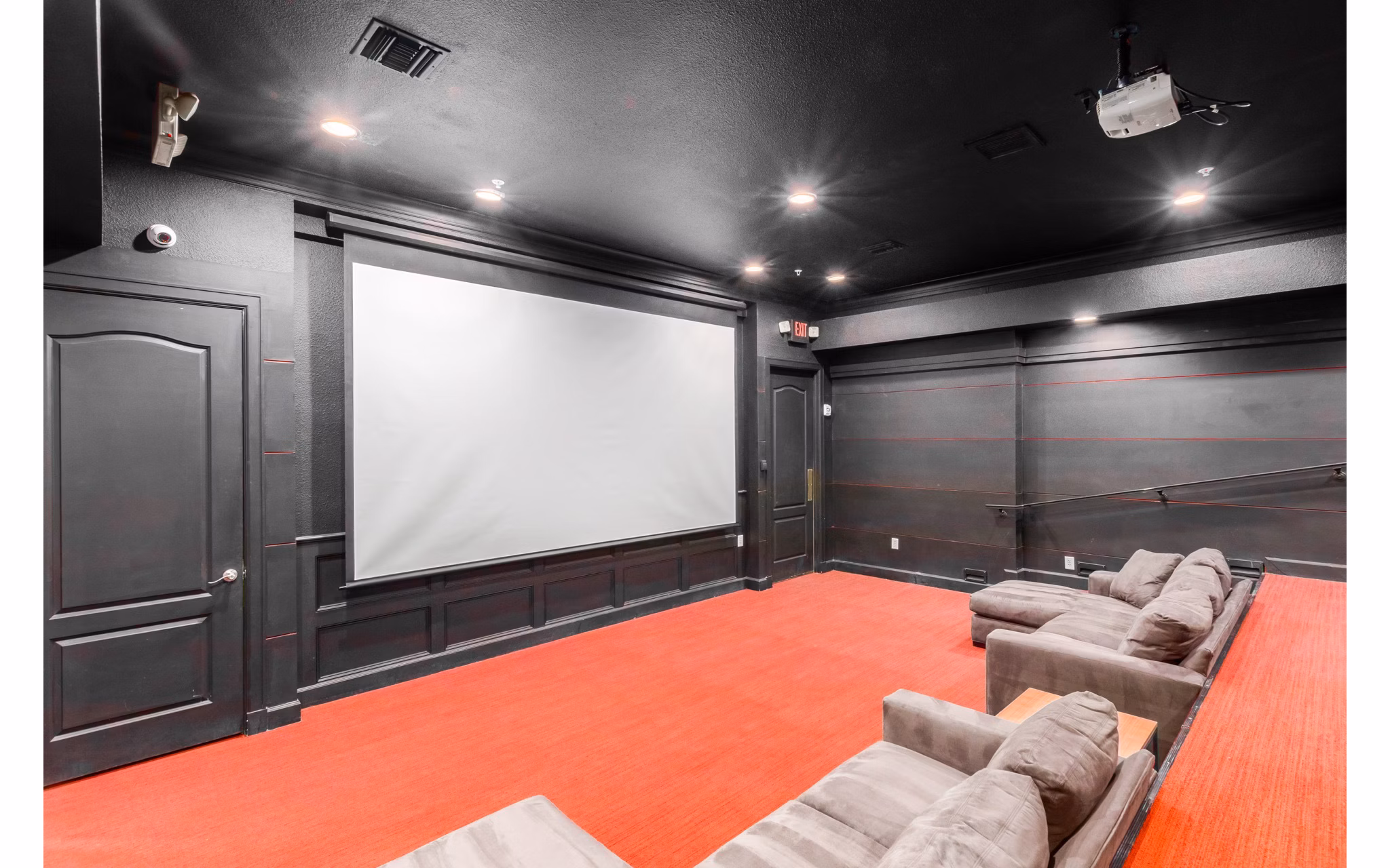Theater room with plush seating and a large screen at Artessa Apartments