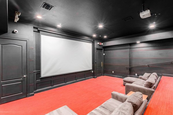 Theater room with plush seating and a large screen at Artessa Apartments