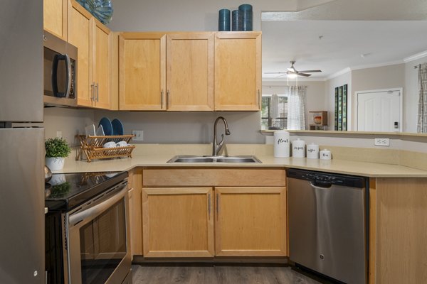 Kitchen featuring modern marble countertops and stainless steel appliances in Artessa Apartments