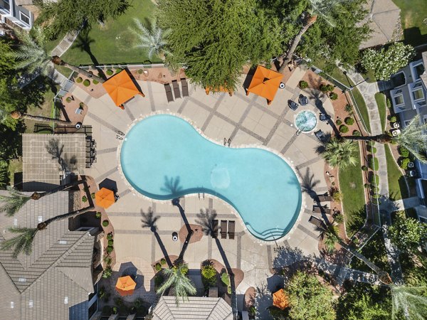 Sparkling outdoor pool with lounge chairs at Artessa Apartments, offering luxury relaxation amenities