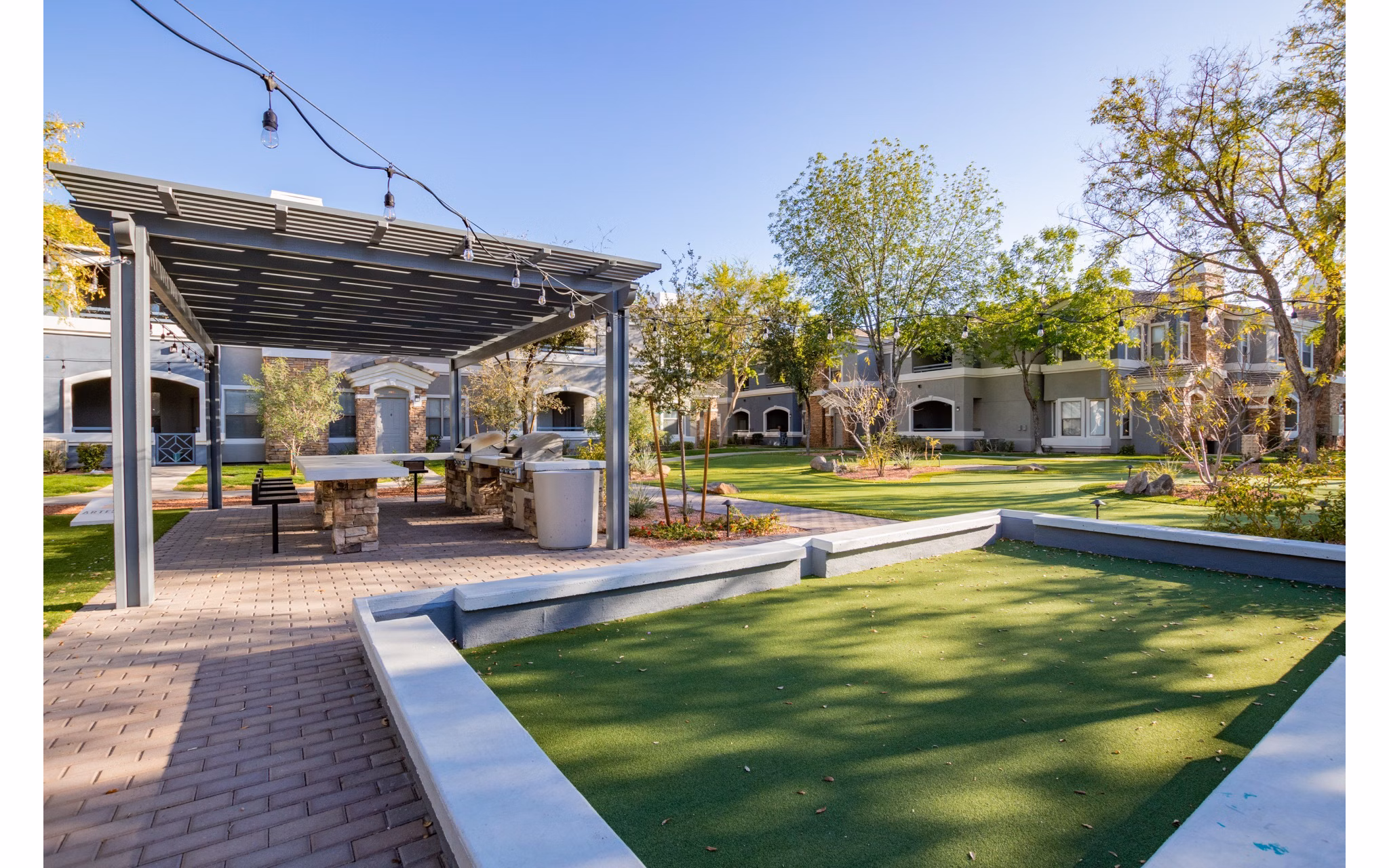 Artessa Apartments: Tranquil courtyard with lush greenery and seating areas in a modern luxury complex