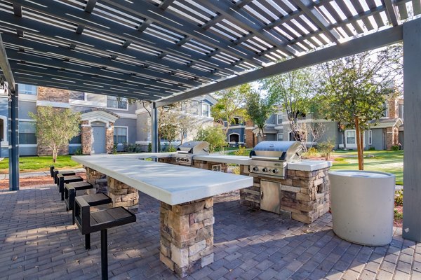 Outdoor grill area with modern furnishings at Artessa Apartments
