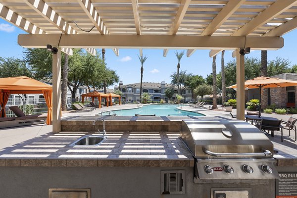 Outdoor grill area with modern seating at Artessa Apartments, ideal for social gatherings and dining al fresco