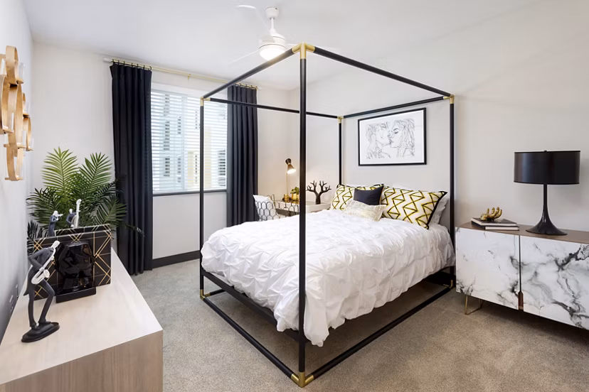 Modern bedroom with plush furnishings at Jefferson Rise Apartments, featuring cozy ambiance and ample natural light in a luxury Greystar community