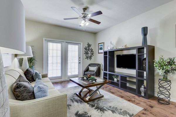 Bright living room with modern furnishings and large windows at Judson Pointe Apartments