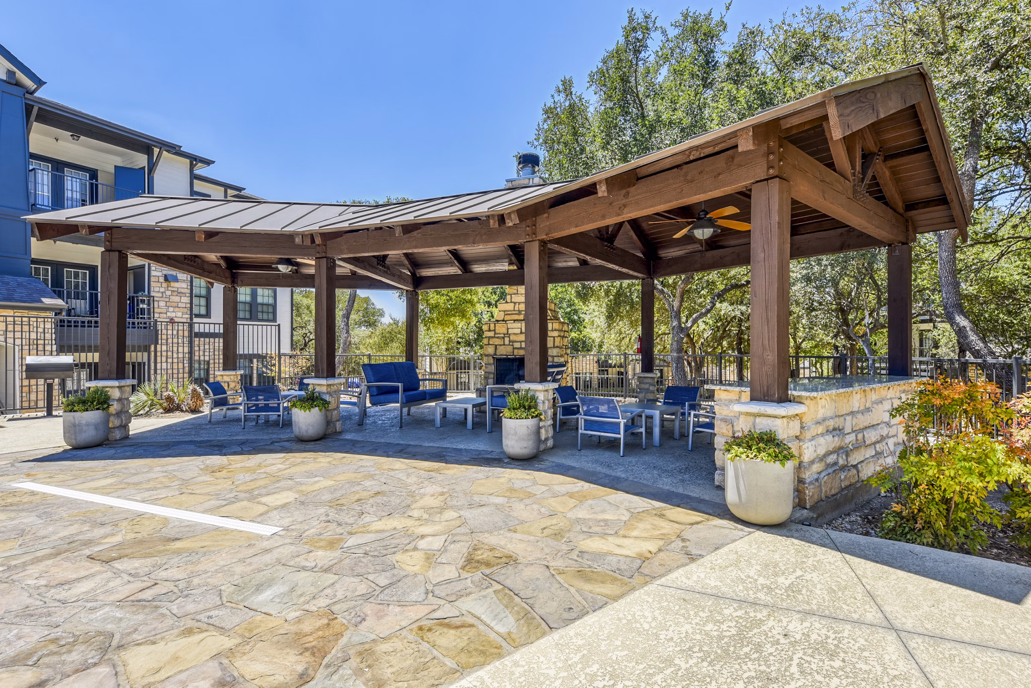 Outdoor grill area and patio at Judson Pointe Apartments featuring modern seating and lush greenery