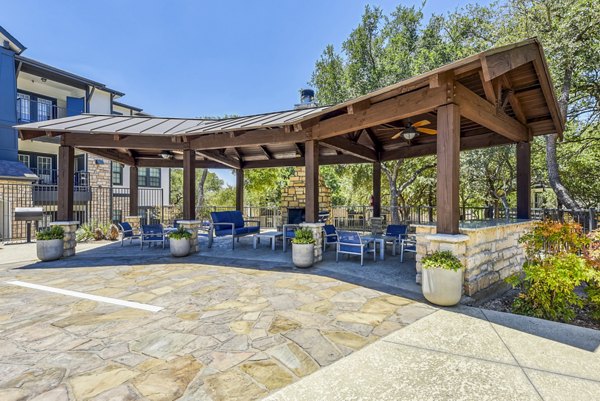 Outdoor grill area and patio at Judson Pointe Apartments featuring modern seating and lush greenery