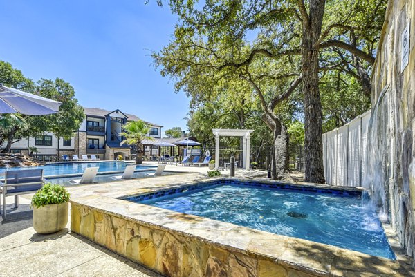 Sunny outdoor pool with loungers and umbrellas at Judson Pointe Apartments, perfect for relaxation and recreation