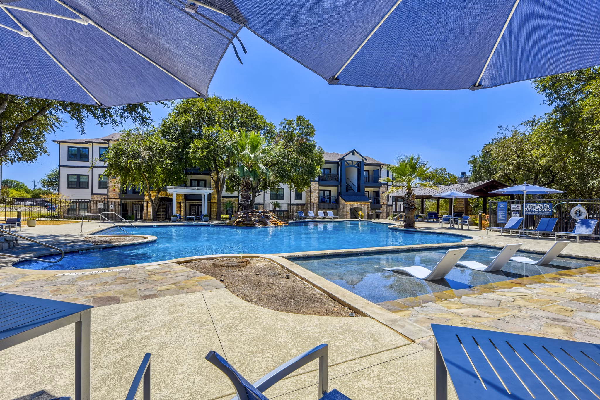 Inviting outdoor pool with lounge chairs at Judson Pointe Apartments, ideal for relaxation and leisure activities in a serene setting
