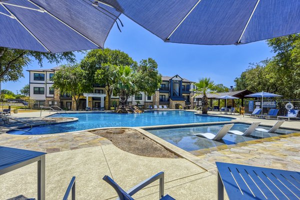 Inviting outdoor pool with lounge chairs at Judson Pointe Apartments, ideal for relaxation and leisure activities in a serene setting