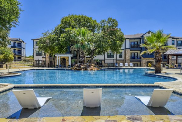 Modern outdoor pool with sun loungers at Judson Pointe Apartments