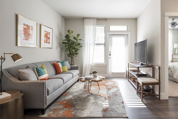 Modern living room with stylish dÃ©cor and a large window at Stella at Riverstone Apartments