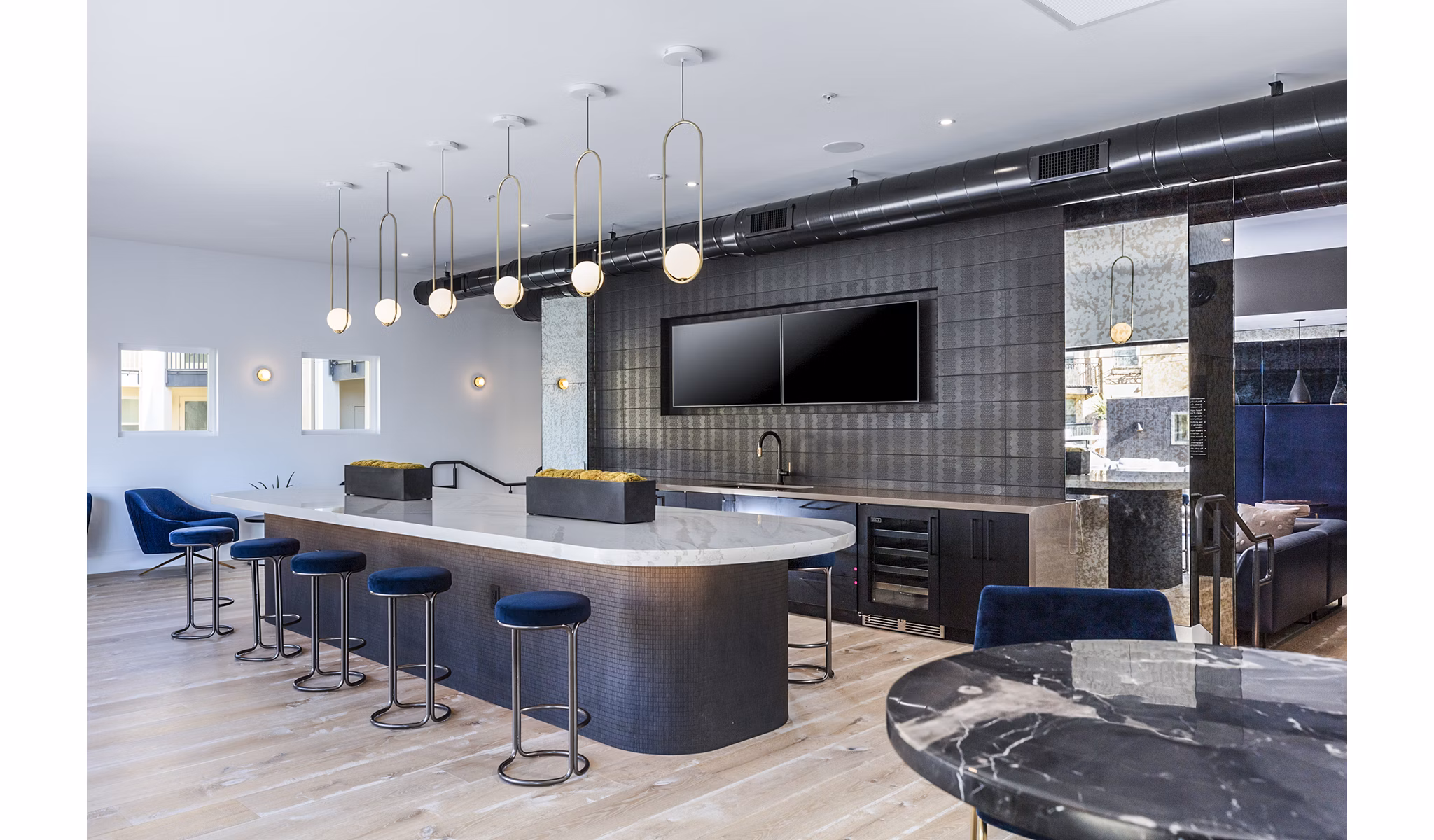 Stylish clubhouse bar with modern decor at Revela Apartments, perfect for social gatherings and relaxation