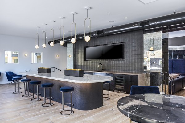 Stylish clubhouse bar with modern decor at Revela Apartments, perfect for social gatherings and relaxation