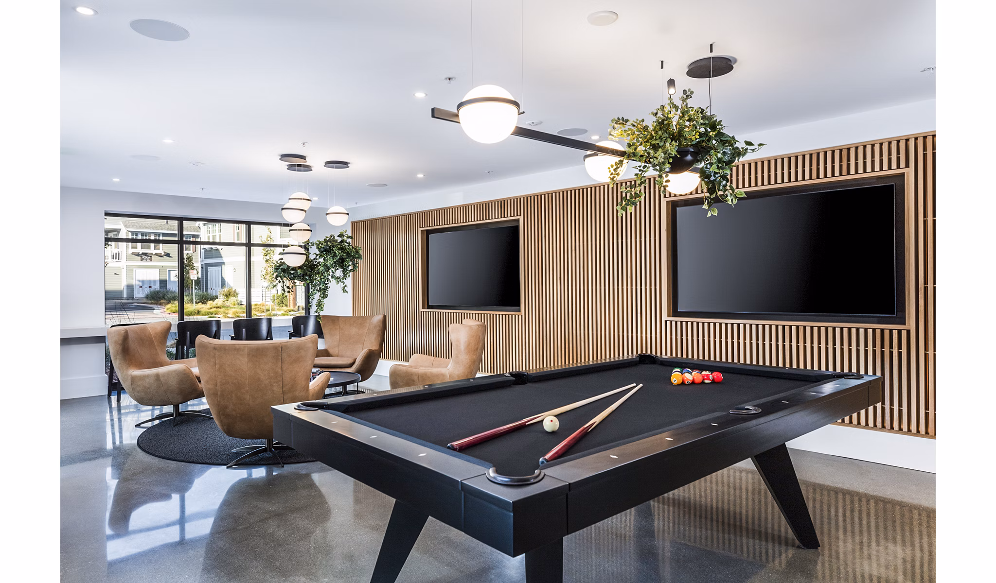 Revela Apartments: Modern game room featuring pool table and arcade games, perfect for entertainment and relaxation
