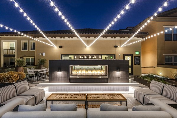 Revela Apartments: Cozy patio balcony with a fireplace for outdoor relaxation in Greystar's luxury community