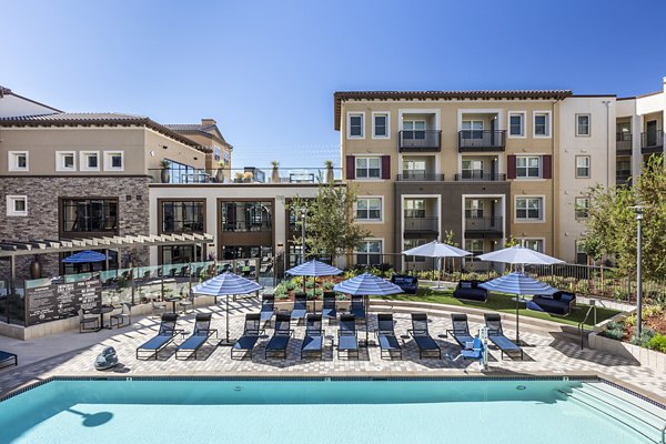 Luxurious pool area with sun loungers at Revela Apartments