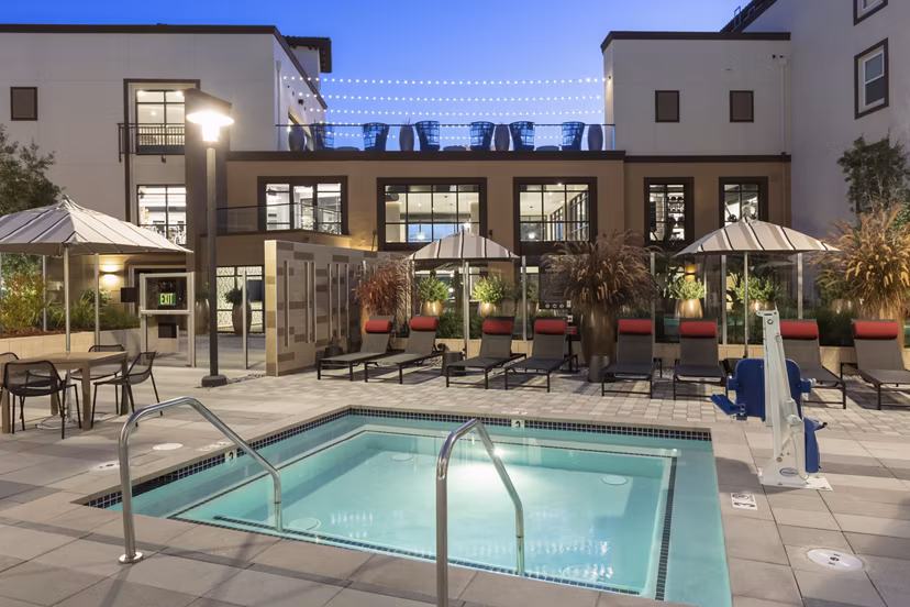 Luxurious outdoor pool area at Revela Apartments with modern seating and lush landscaping, perfect for relaxation and social gatherings