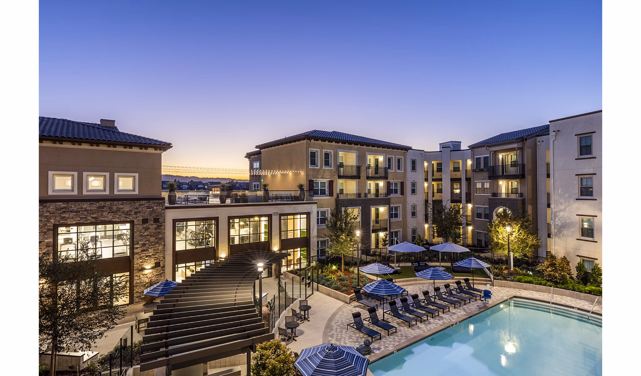 Stunning outdoor pool at Revela Apartments with resort-style seating and lush landscaping