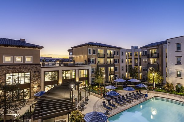 Stunning outdoor pool at Revela Apartments with resort-style seating and lush landscaping