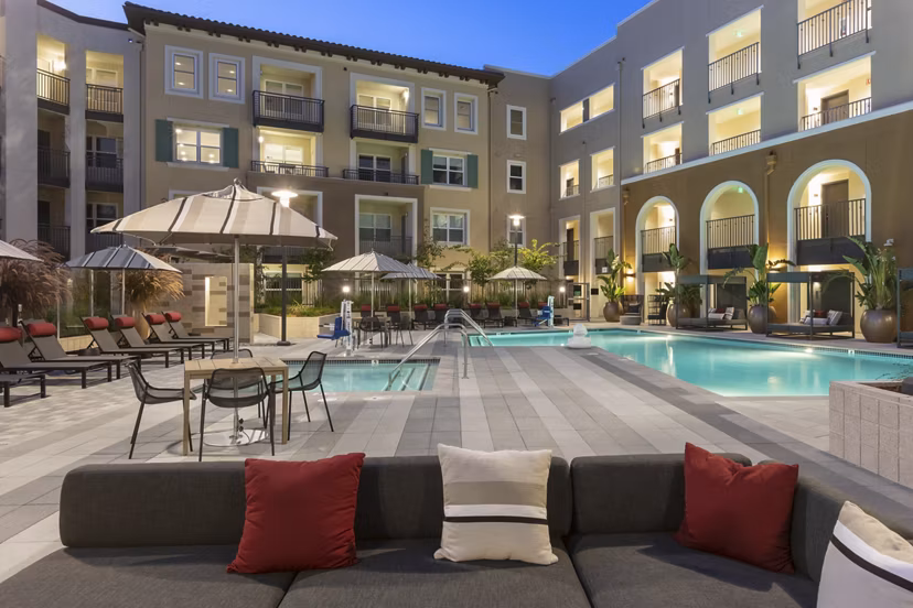 Luxurious pool area with sun loungers at Revela Apartments, a Greystar luxury community
