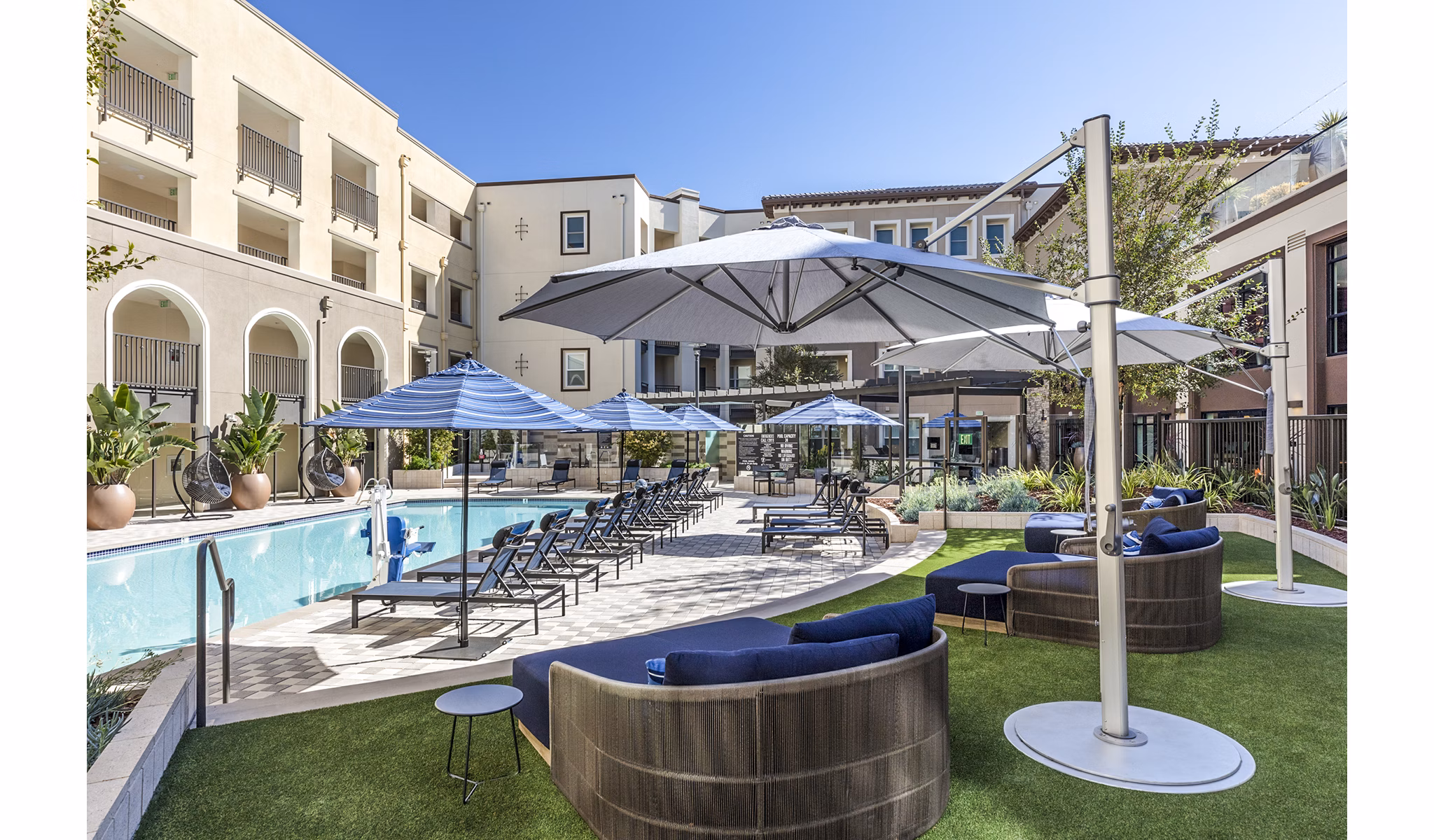 Luxurious pool area with sun loungers at Revela Apartments, a Greystar luxury community