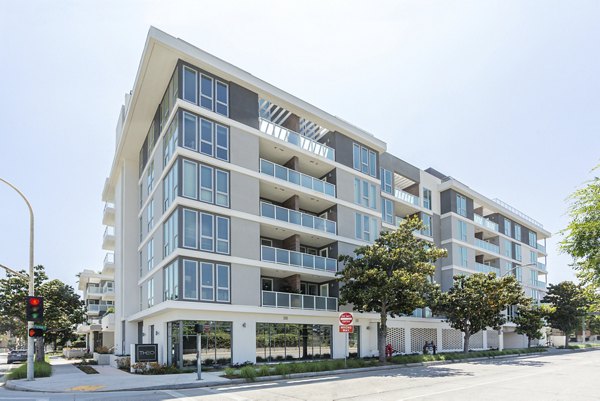 Theo: Modern luxury apartment building with sleek design and green spaces